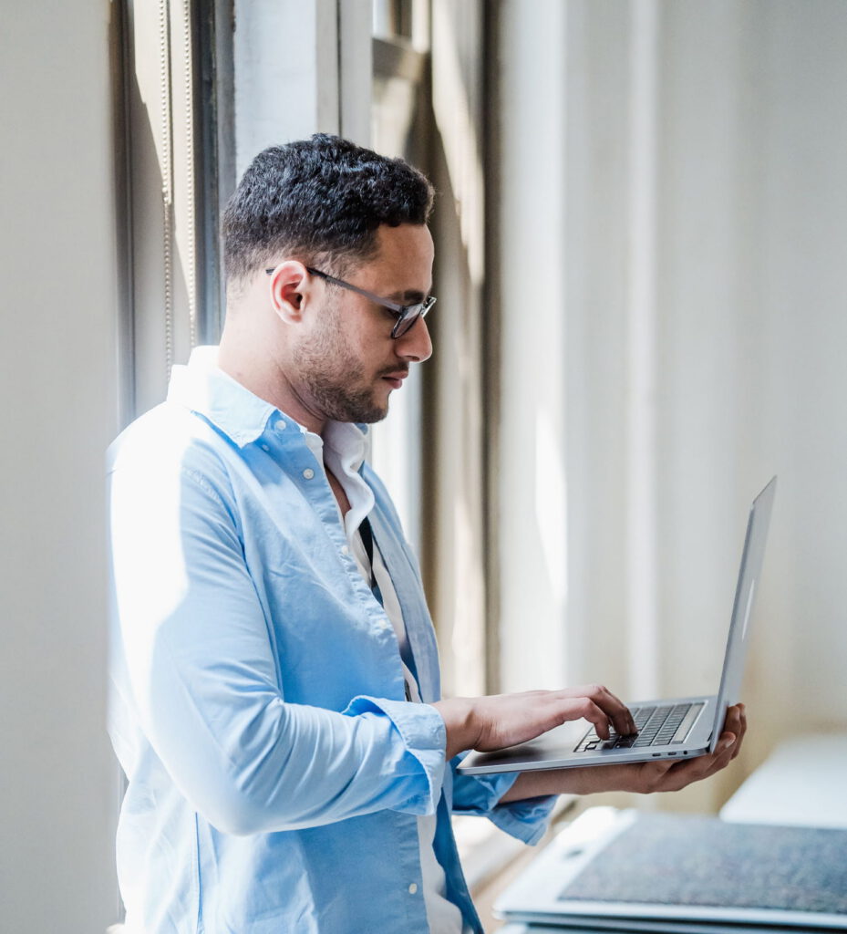 Aan man aandachtig aan het werk met de laptop in zijn hand