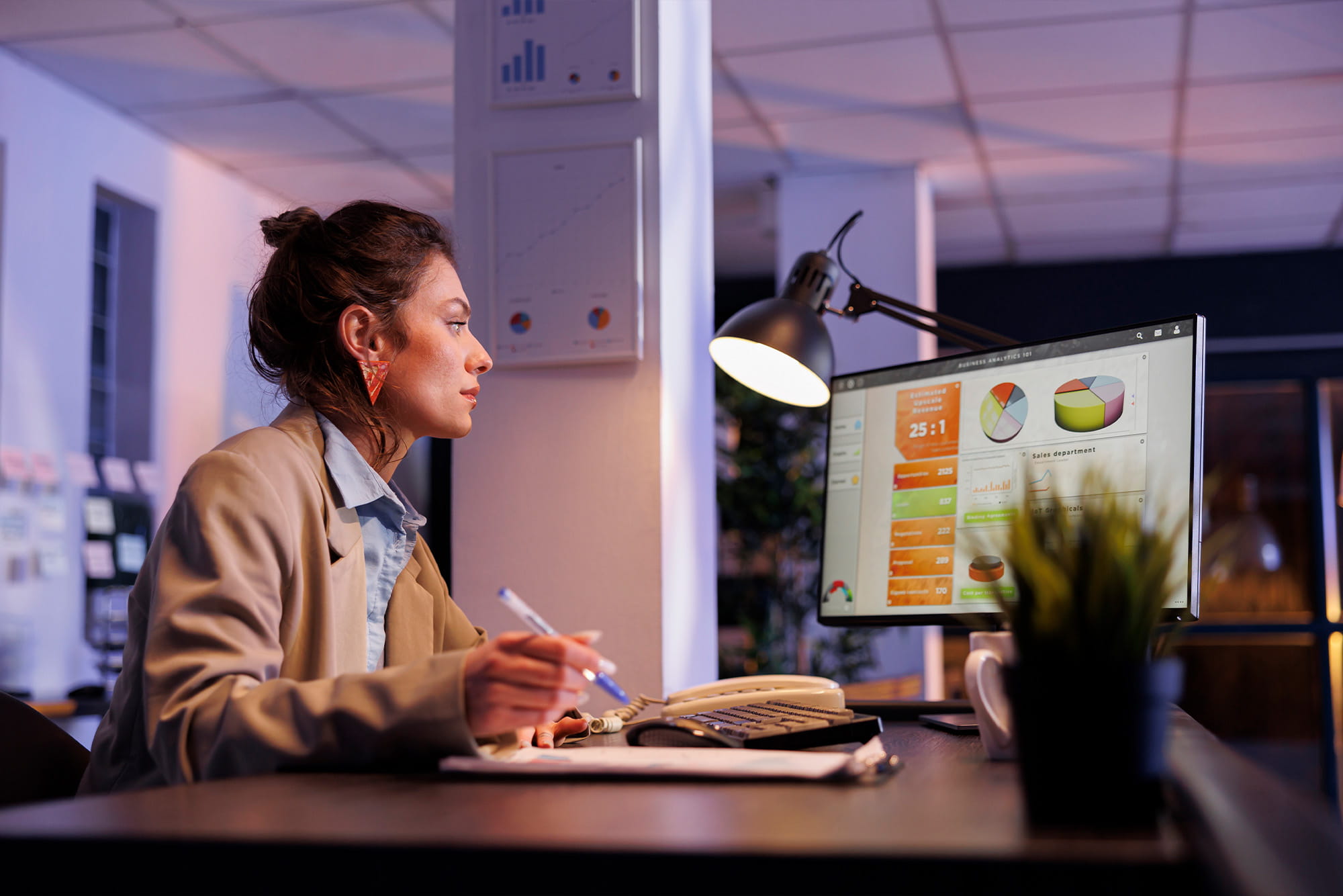 Geconcentreerde vrouw achter computer bezig met het analyseren van dashboards.
