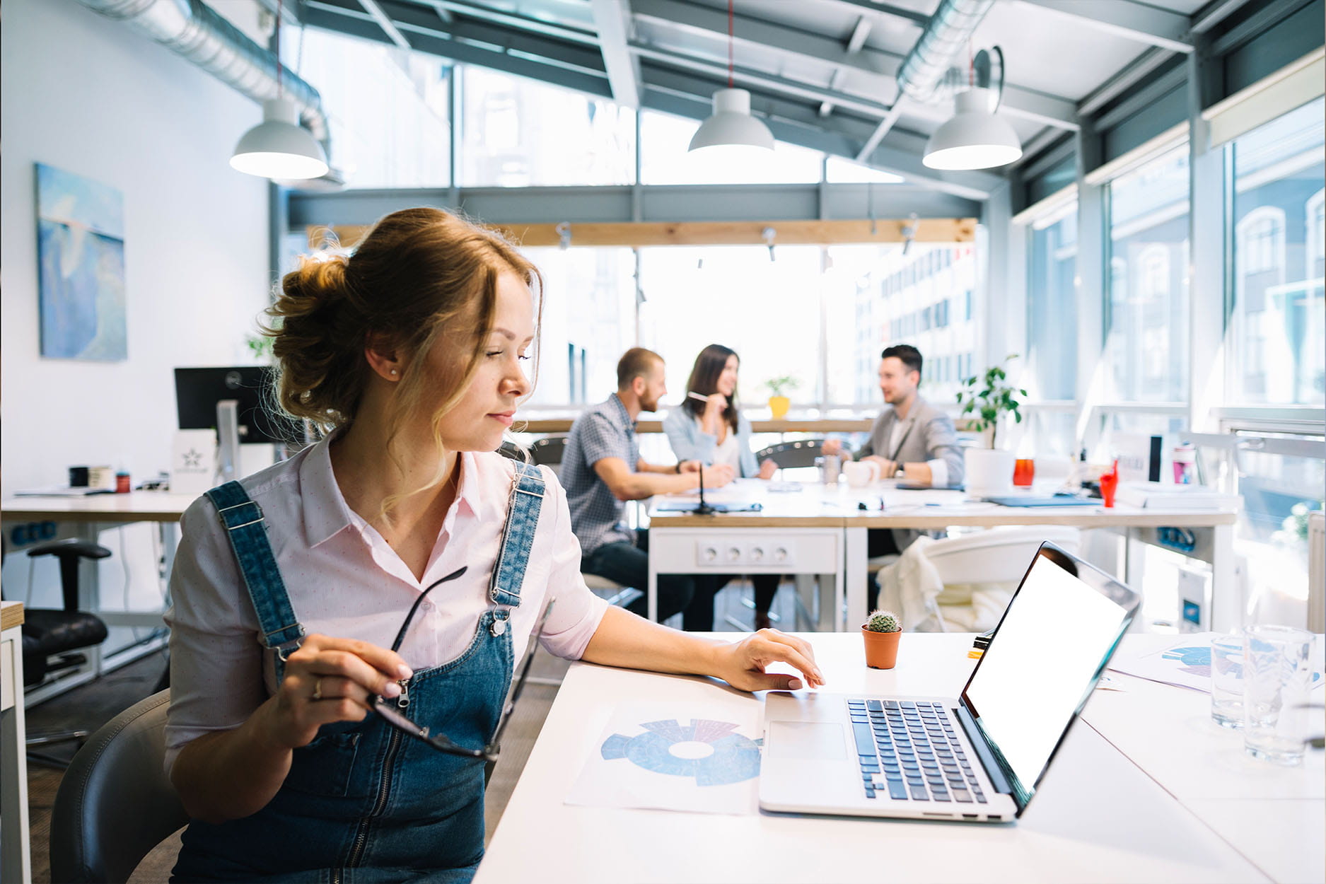 Een vrouwelijke medewerker op kantoor achter haar laptop